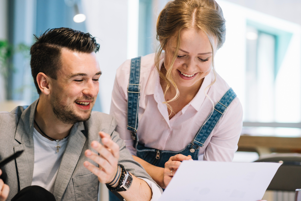 Un couple souriant devant une feuille