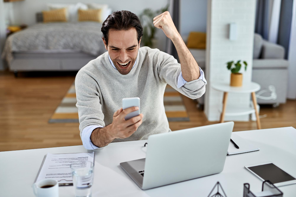 un homme content en regardant son téléphone